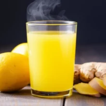 A-glass-of-lemon-ginger-juice-with-fresh-lemons-and-ginger-roots-beside-it.
