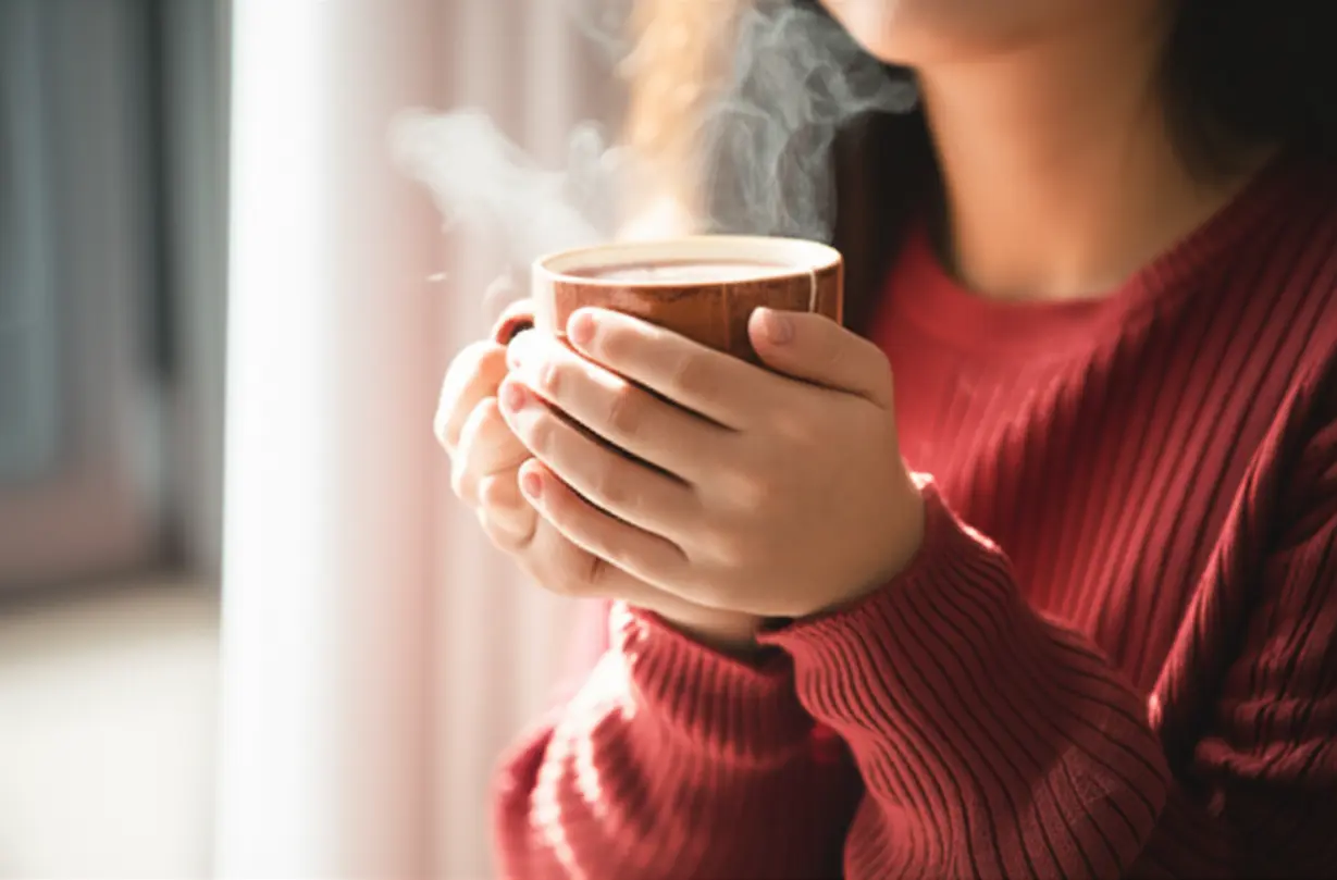 A-person-breathing-easily-and-comfortably,-holding-a-cup-of-tea,-symbolizing-respiratory-relief.